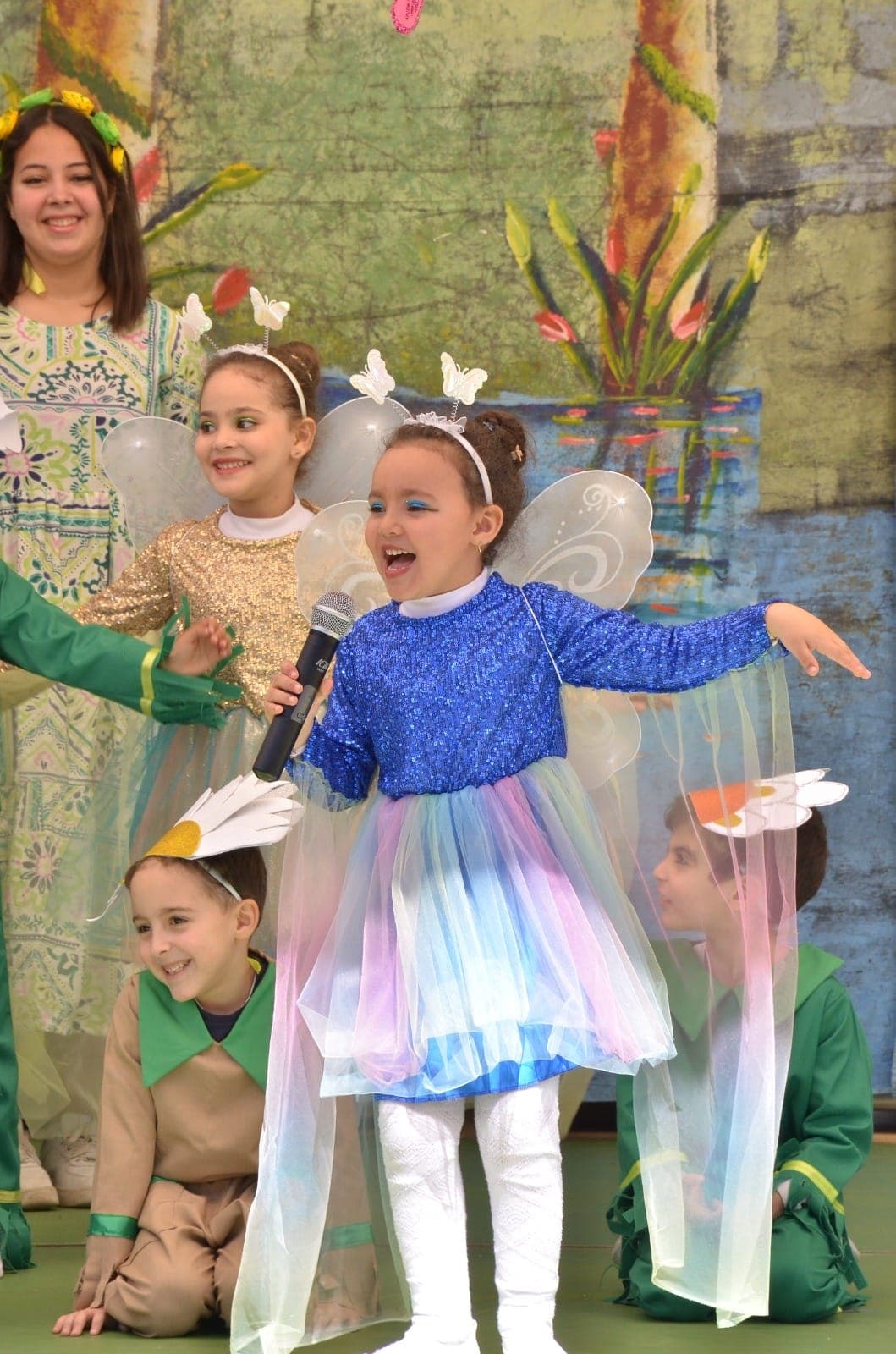 Élève en costume de papillon lors d'un spectacle